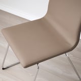 Modern chair with beige upholstery and chrome legs on light wooden floor.