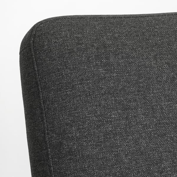 Close-up of EKENÄSET chairs plush black fabric, showing smooth, even stitching and high-quality upholstery.