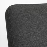 Close-up of EKENÄSET chairs plush black fabric, showing smooth, even stitching and high-quality upholstery.