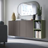 Modern wall-mounted cabinet: EKET. Gray-brown, 4 doors, integrated shelves. Its large, housing books, plants, mirror, near a couch.