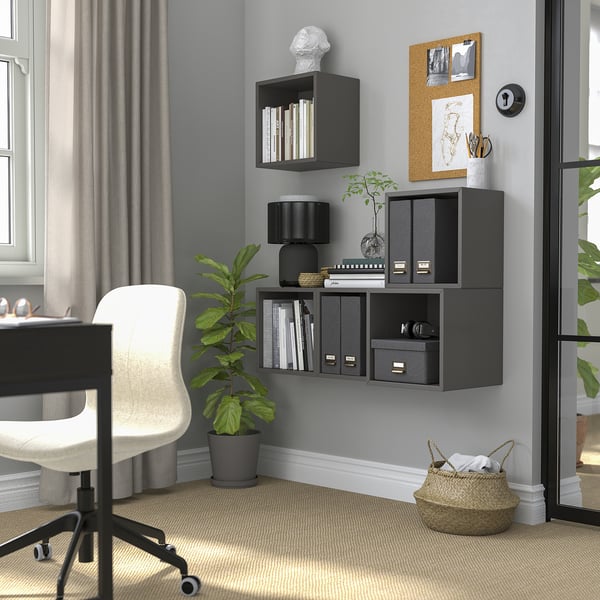 Home office with dark gray EKET shelves. Plants, basket, and white desk/chair setup nearby a large window.