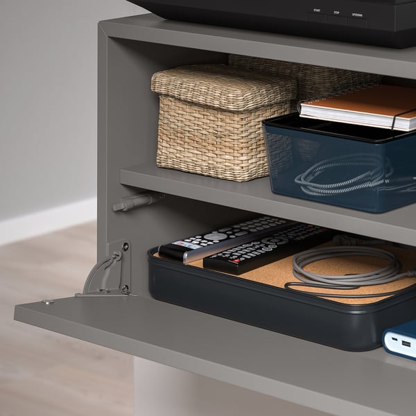 Wall-mounted organizer with pull-out tray for remotes, keeping media unit tidy.