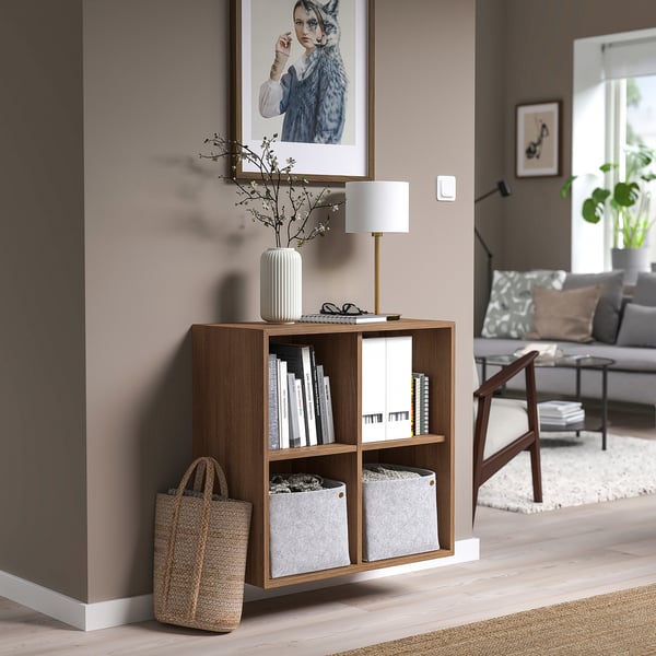 Wooden EKET cabinet with lamp, vase, basket, and sofa.