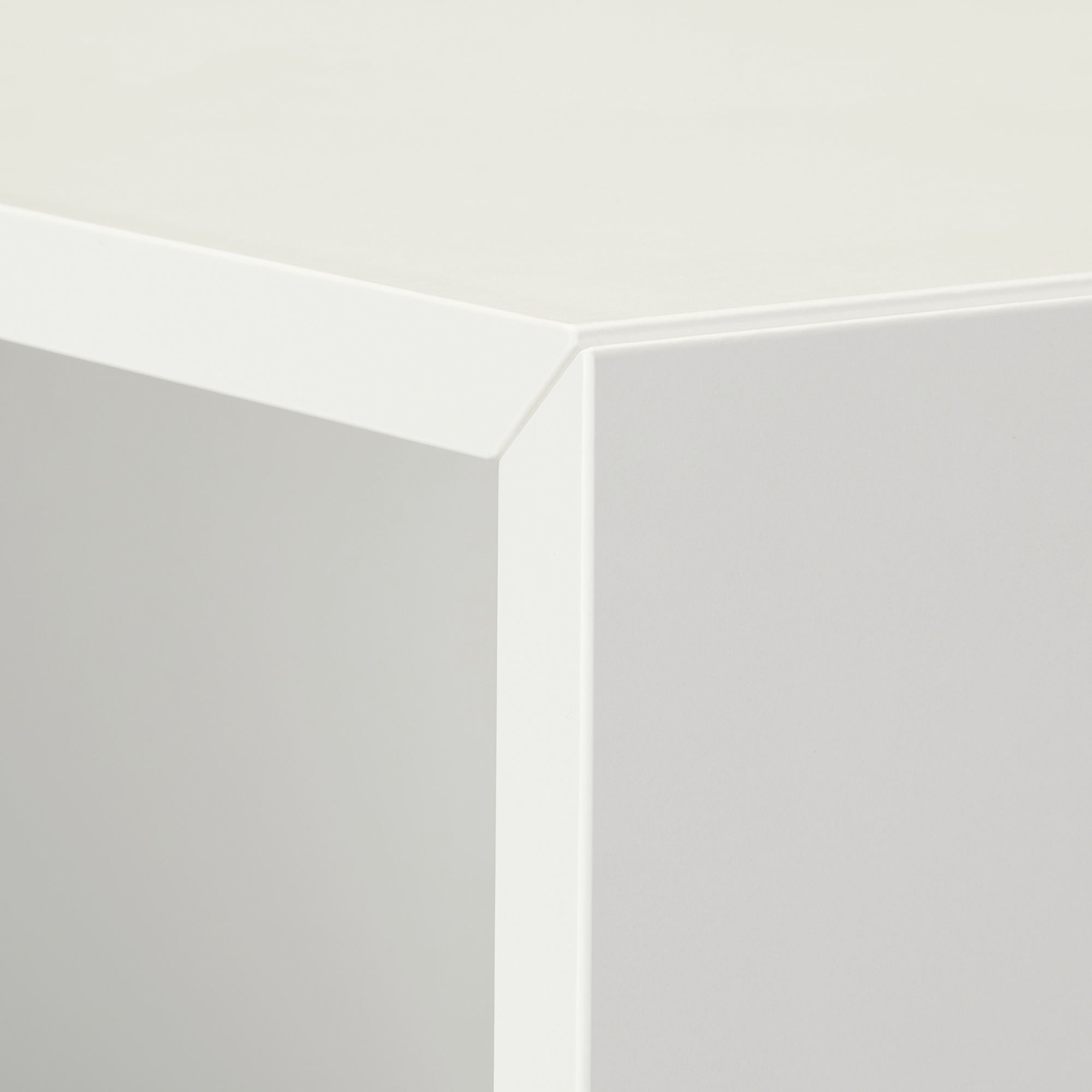 Close-up of pristine white corner of modern storage unit. Smooth surfaces, clean edges, minimalist design.