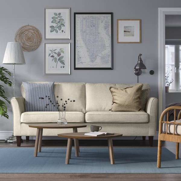 Living room with beige sofa, blue walls, rug, coffee table, and decor.