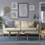 Living room with beige sofa, blue walls, rug, coffee table, and decor.