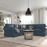 Main modern living room with large blue EKTORP sectional sofa, wooden coffee table, pendant light, and white curtains.