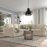 Beige EKTORP sectional, soft cushions. Modern living room with rug, wood floor, industrial lamp, plants.