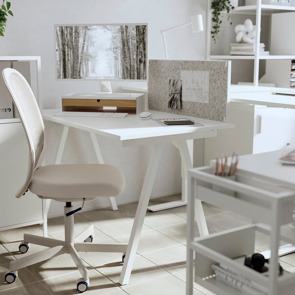 Minimalist white desk with bamboo drawers, chair, monitor stand, and organizer; clean, modern workspace for productivity.