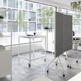 Modern office setup with white ELLOVEN mobile whiteboards on wheels, double-sided for writing and pinning notes, positioned near large windows.