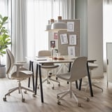 Modern office with four beige chairs, central table, and double-sided whiteboard with notes and lights.