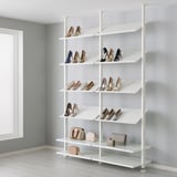 White shoe rack with multiple shelves holding various heels and purses. Shelves are adjustable and floor-to-ceiling height.