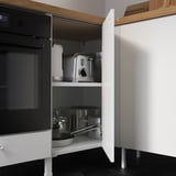 Modern kitchen cabinet with pots, pans, and appliances. Open door reveals organizational storage.