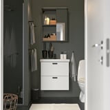 Modern bathroom with white ENHET vanity, mirror, toilet, and gray walls.