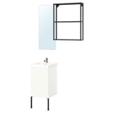 A modern bathroom setup: white cabinet with black legs, black-framed mirror, sleek sink with chrome tap.