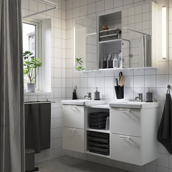 ENHET white vanity with mirrors, 2 sinks, open shelves & folded towels. Symmetrical, modern, minimalist design.