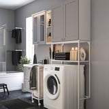 Modern grey laundry-bath combo; white washer, open shelves, glass doors, mirror.