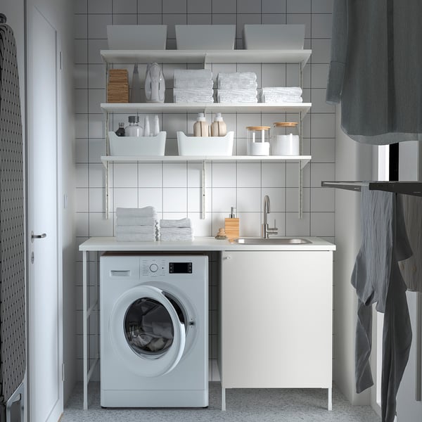 Small, white laundry unit with sink & cabinets, efficiently organized with storage shelves above.