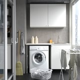 Modern laundry nook with ENHET cabinets, washing machine, sink, and drying rack by window.