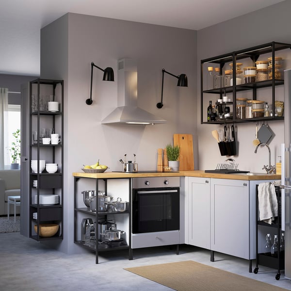 Modern kitchen with grey ENHET cabinets, wooden counter, stainless appliances, and wall-mounted shelves.
