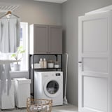 Compact laundry area with ENHET wall unit in grey, housing washing machine, open shelves, and closed cabinets, neatly organizing laundry essentials.