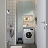 Modern laundry with ENHET wardrobe, washing machine, and organized accessories.