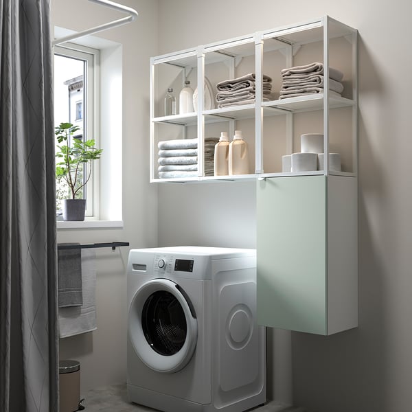 Grey-green ENHET storage unit above washing machine in bathroom, holding towels & laundry.