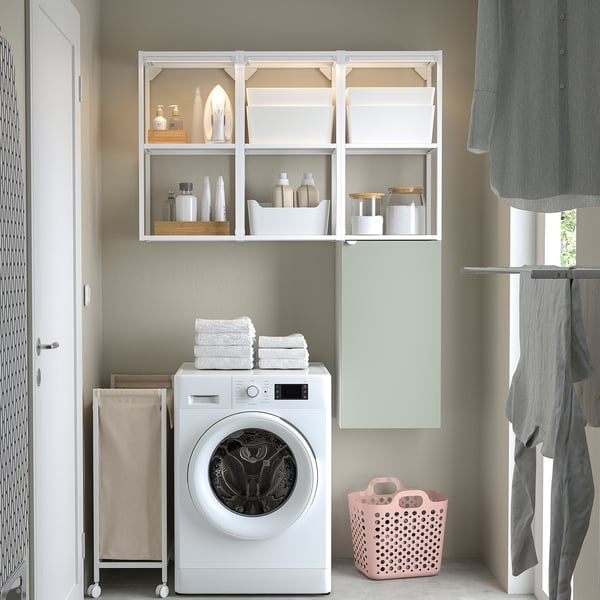Pale grey-green ENHET storage in laundry room, displaying towels, supplies, and machine.