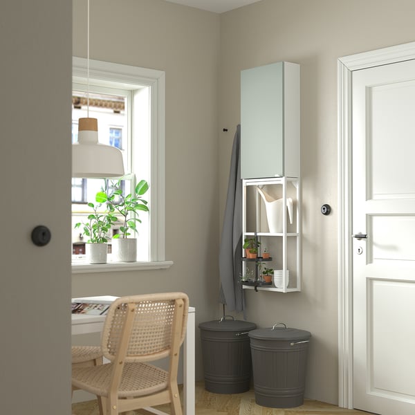Modern entryway with ENHET cabinet, chair, window, plants.