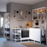 Contemporary white kitchen setup with open shelves, stainless steel appliances, and black accents.