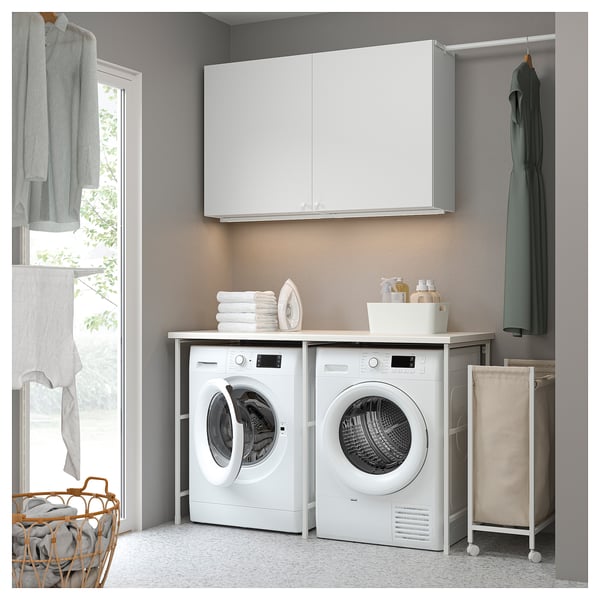 Modern laundry room with ENHET cabinets, washer, dryer, clothes rod, and window.