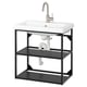 Modern black metal sink stand with white ceramic basin, sleek faucet.