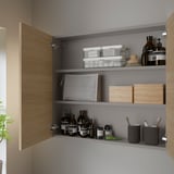 Modern oak bathroom cabinet organizes toiletries.