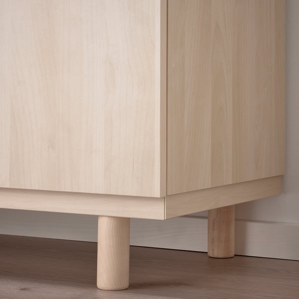 Light wooden cabinet with smooth, light-colored finish. Three cylindrical legs for support, displaying fine craftsmanship.