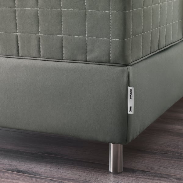 Close-up of high-quality green sofa with sleek metal legs and detailed stitching.