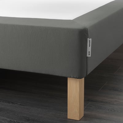 Grey upholstered bed base with wooden legs, supports mattress, elevates bed height.