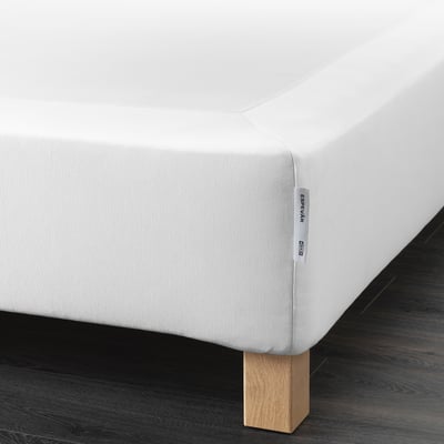 Corner of white ESPEVÄR mattress base with wooden legs, providing support and elevating bed height.