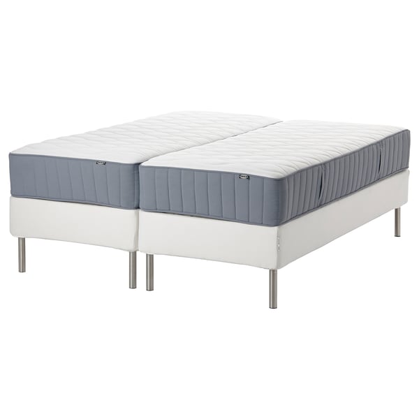 Two white mattresses on a white base with metal legs, blue trim.