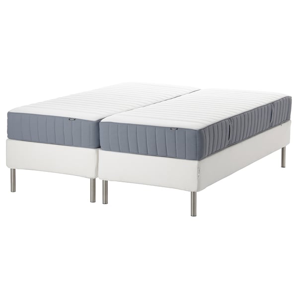 Two ESPEVÄR/VALEVÅG mattresses on a white bed base, grey and white in color, with stainless steel legs.