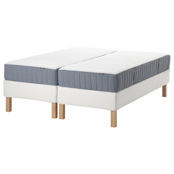 Two beds with blue-grey mattresses and light wooden legs, modern minimalist design.