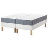 Two beds with blue-grey mattresses and light wooden legs, modern minimalist design.