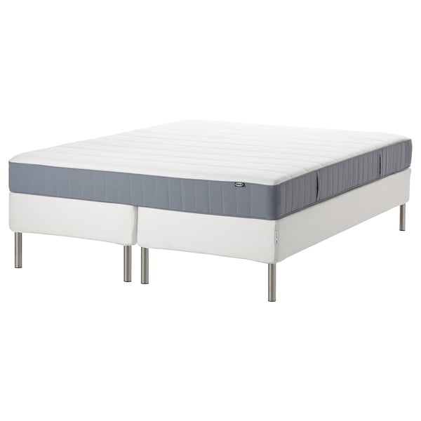 White and gray rolled mattress on white bed frame.