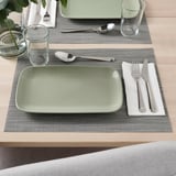 Table setting with FÄRGKLAR plate, glass, and cutlery. Place mat and napkin included.