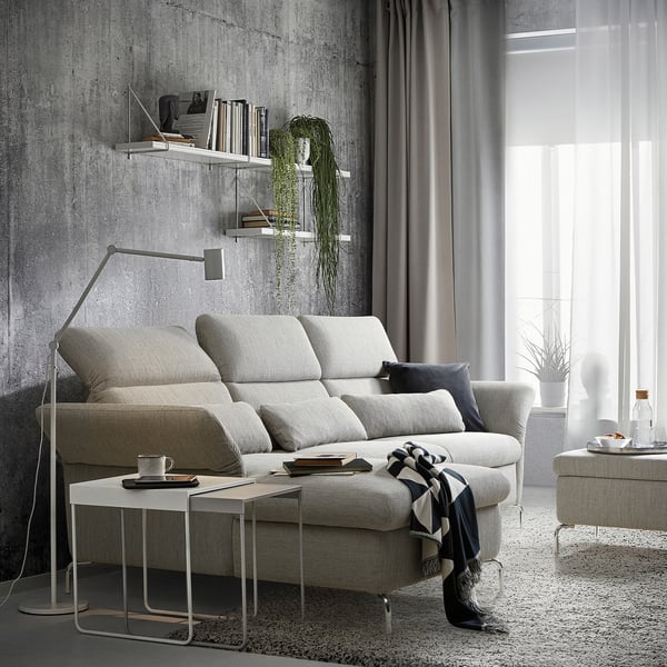 Modern living room with gray FAMMARP sofa, white coffee table, hanging plants, and large window with curtains.