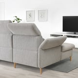 Gray sectional sofa with adjustable parts, white wall, tv, and blue rug.