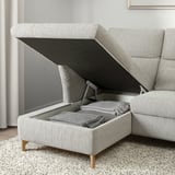 Sofa with open storage compartment, pillows inside.
