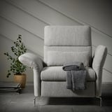 Modern gray tweed FAMMARP recliner with footstool, sleek metal legs, comfy blanket, cozy setup.