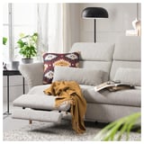FAMMARP sectional sofa with adjustable headrests and mustard throw. Pillow, book, lamp, plant in cozy living space.