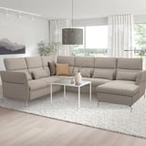 Modern neutral-toned l-shaped FAMMARP sofa with adjustable parts. Large, cozy, fits well in spacious rooms. Centered coffee table with decor.