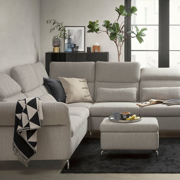 Modern living room with a gray FAMMARP sectional sofa, featuring cushions, a footstool, and decorative items.